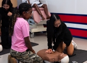 Two students doing CPR on dummy.